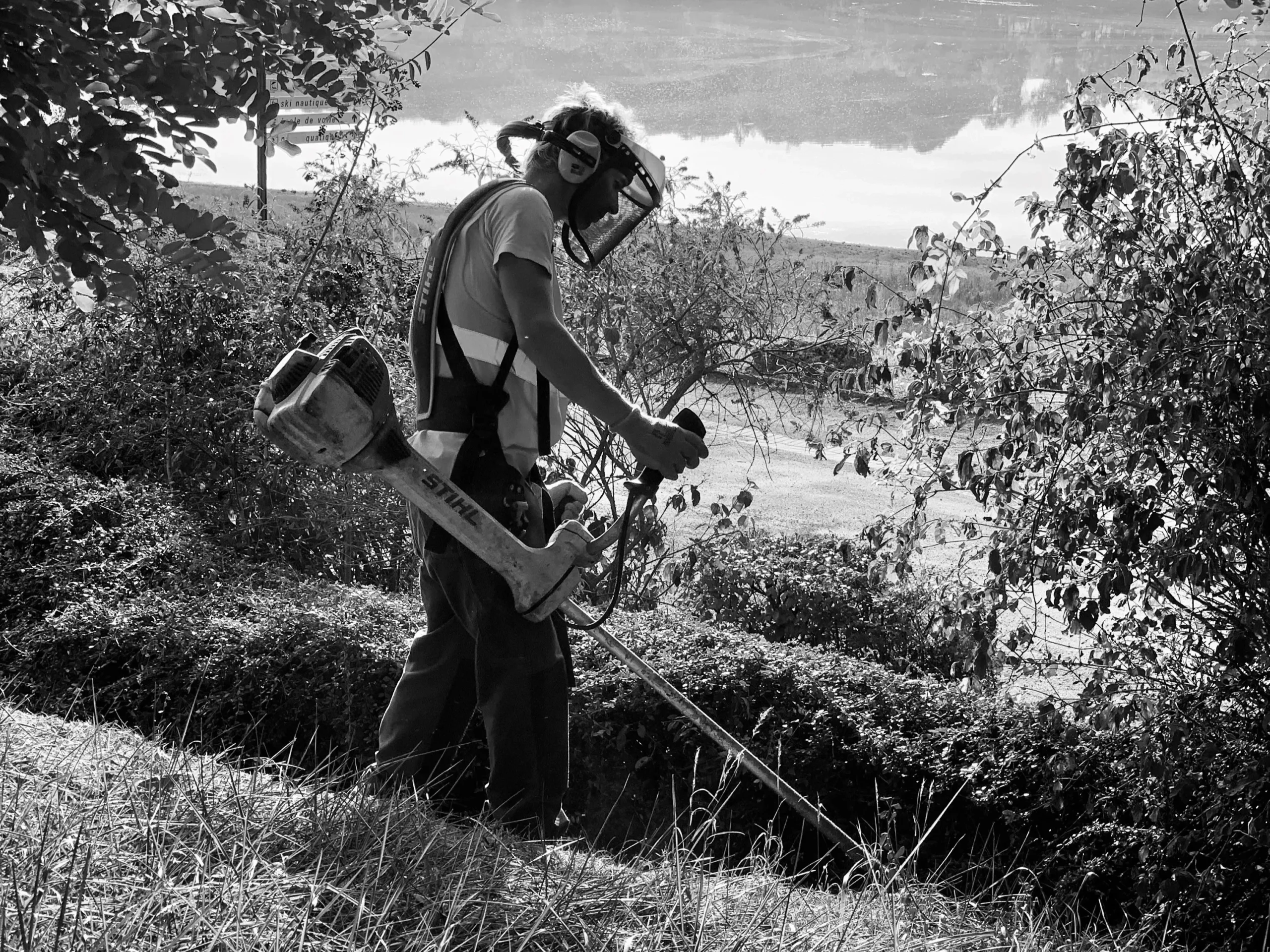 Salarié de DEFIS réalisant des travaux de débroussaillage dans le cadre de l’activité espaces verts.